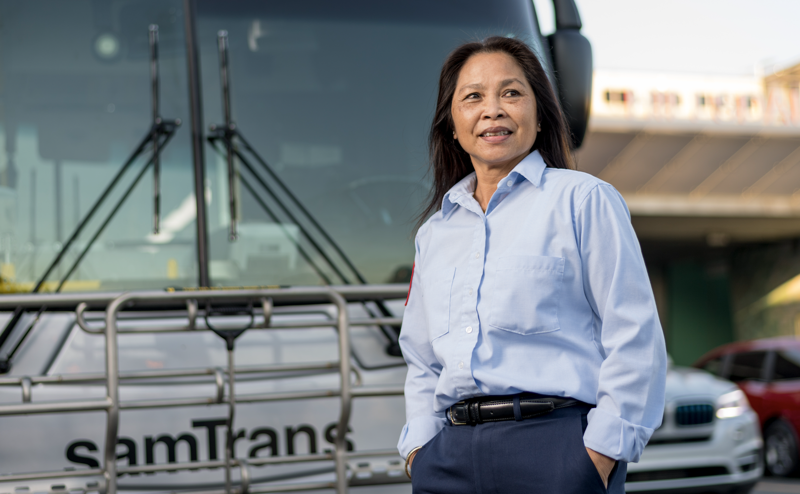 A SamTrans operator stands in front of her bus