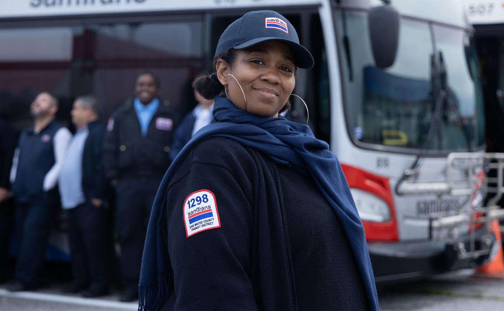 Driver posing by SamTrans Bus