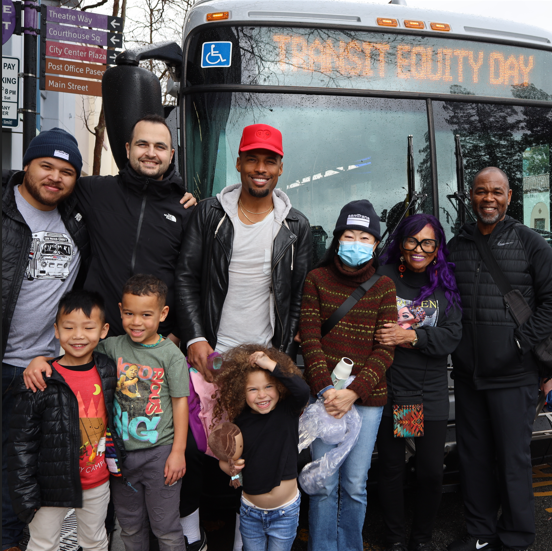 SamTrans employees and riders stand in front of a bus on Rosa Parks Birthday.